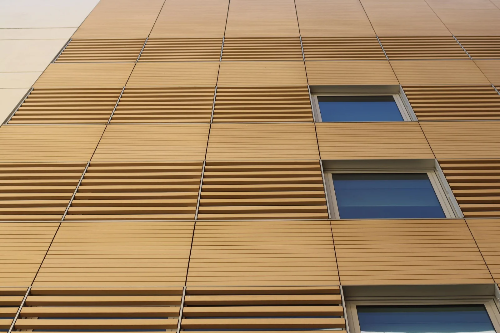 Lames de bois et fenêtres sur une façade ventilée